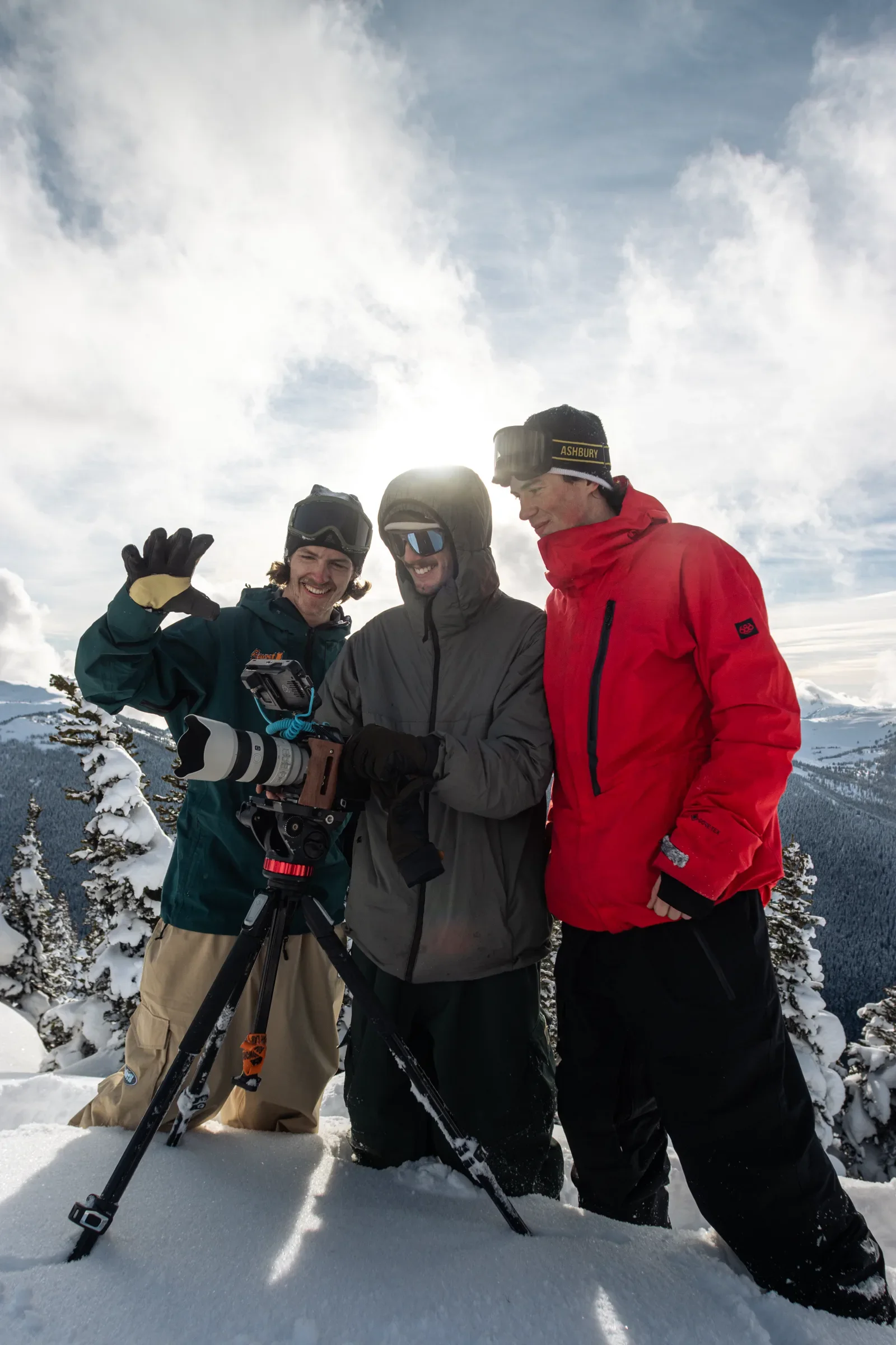 A production team gathered around a camera on a snowy ridge