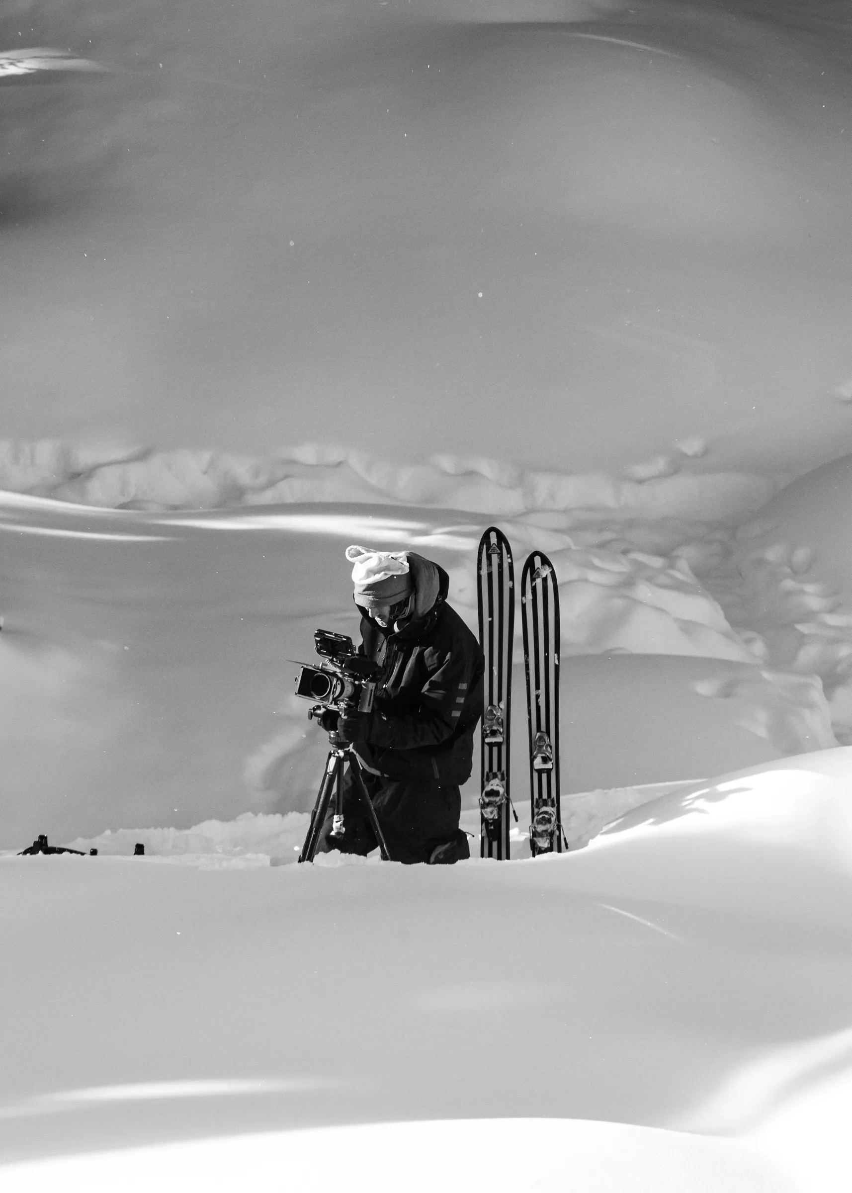 A camera operator setting up a cinema camera in deep snow