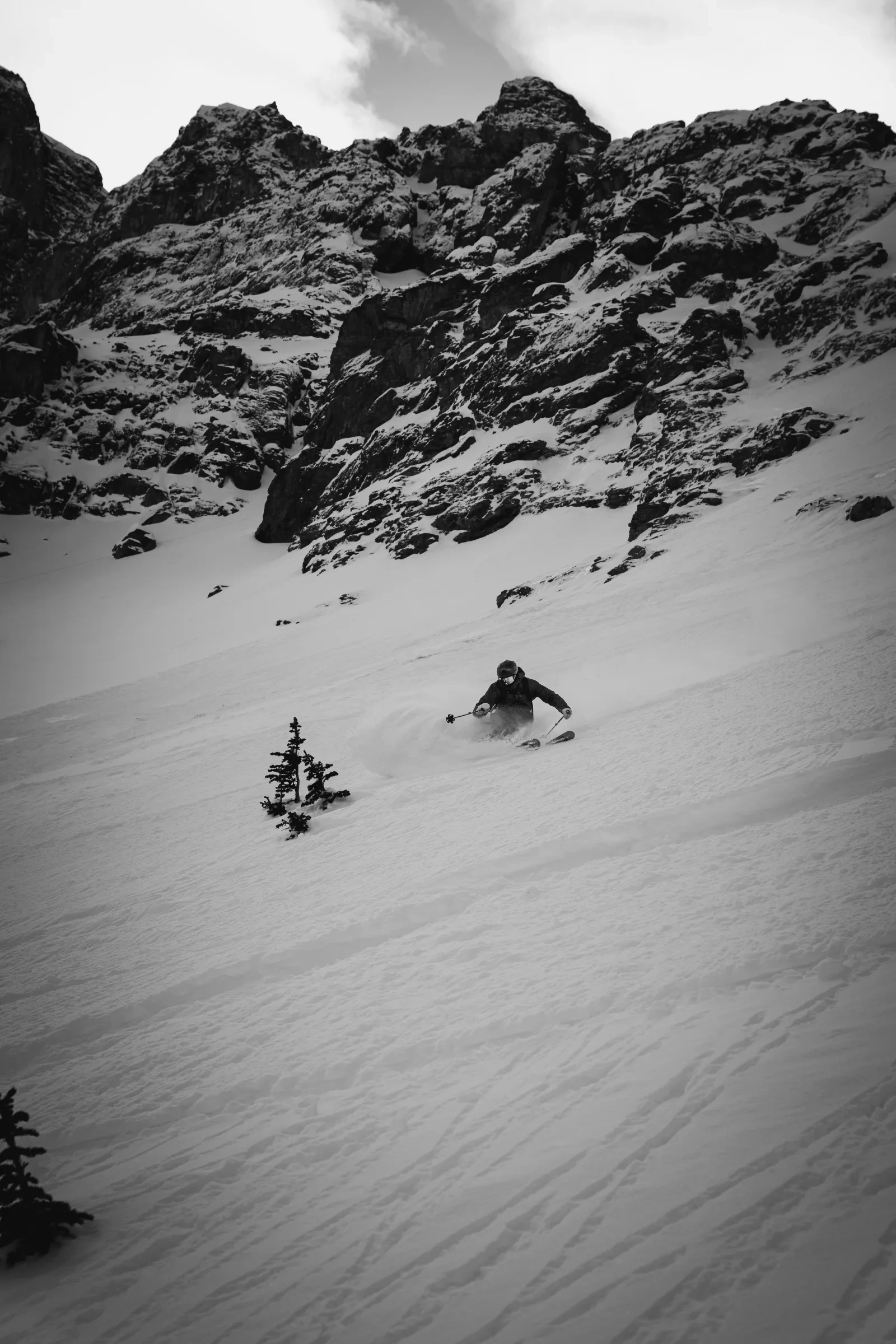 A skier cutting across a high alpine face