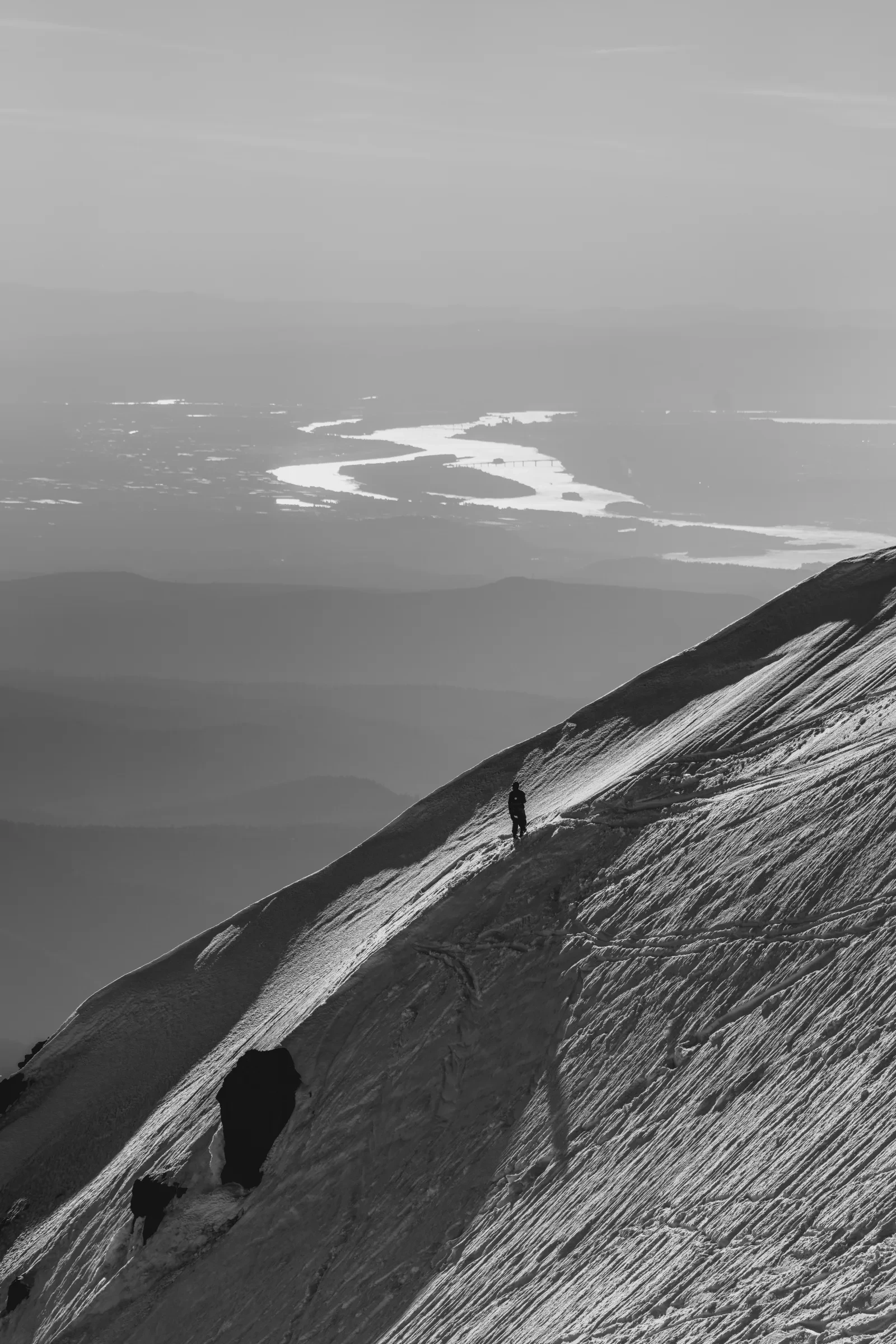 Two figures looking across the mountain from a high ridge