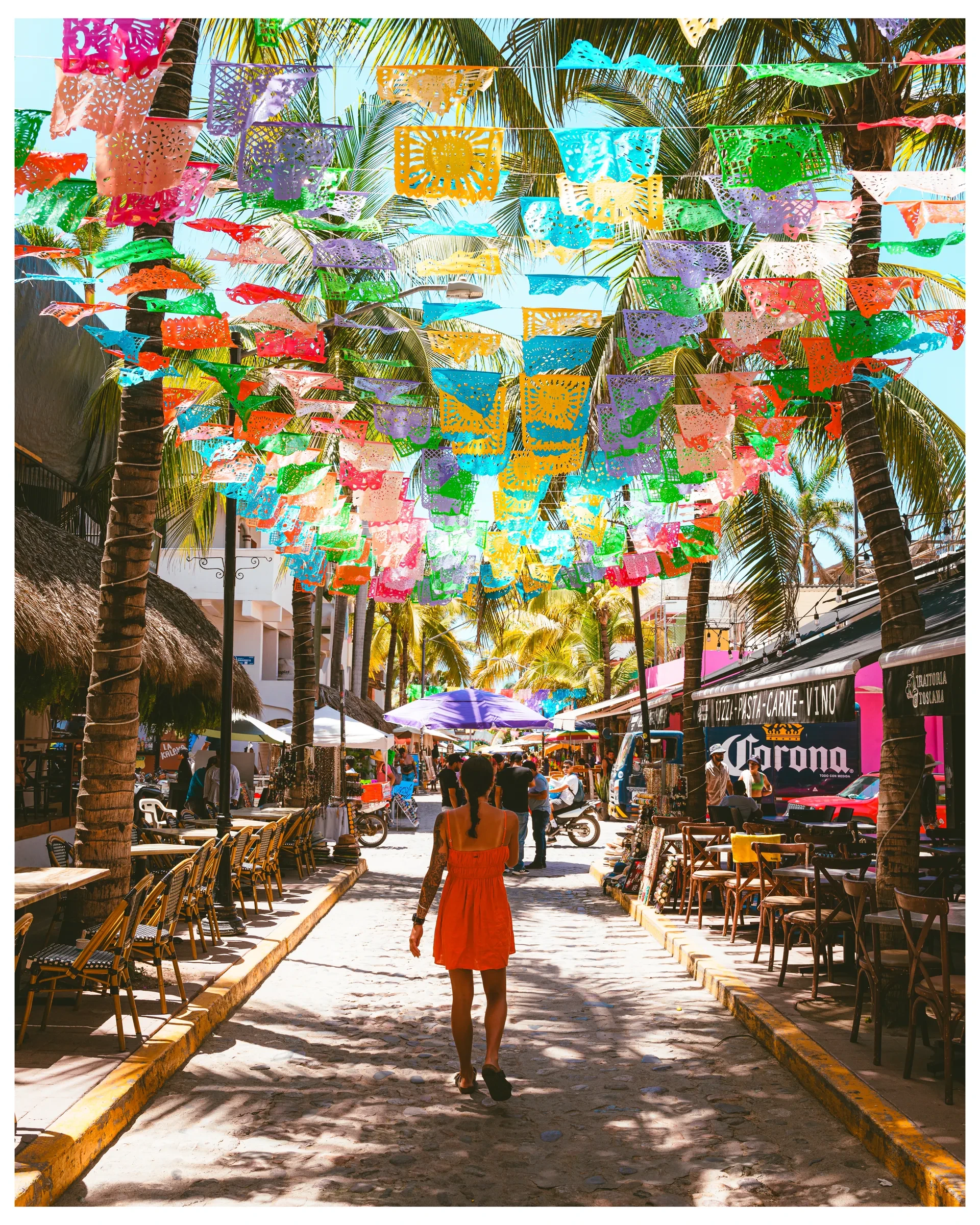 Colourful flags hanging above a narrow street