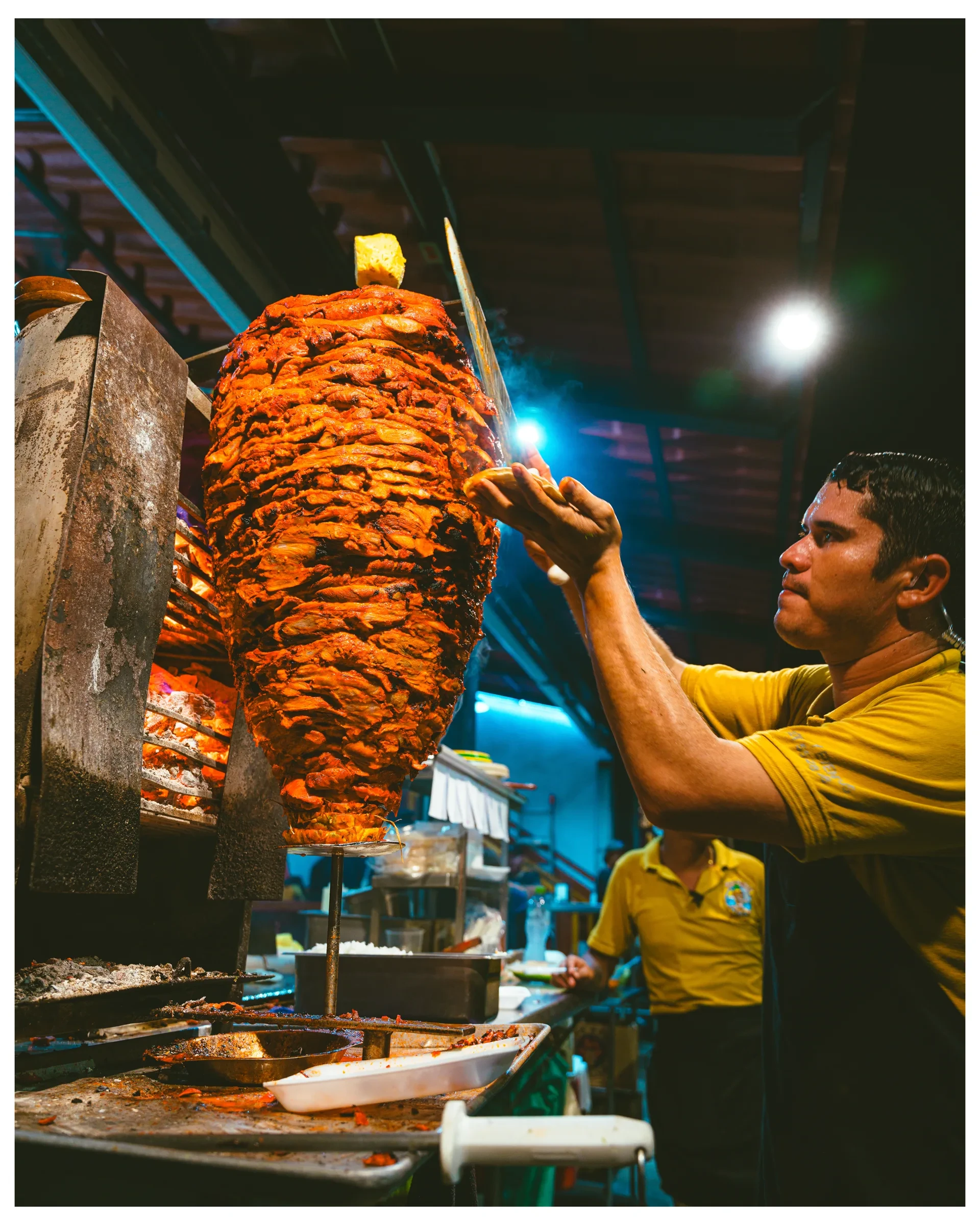 A street-food vendor working beside a grill