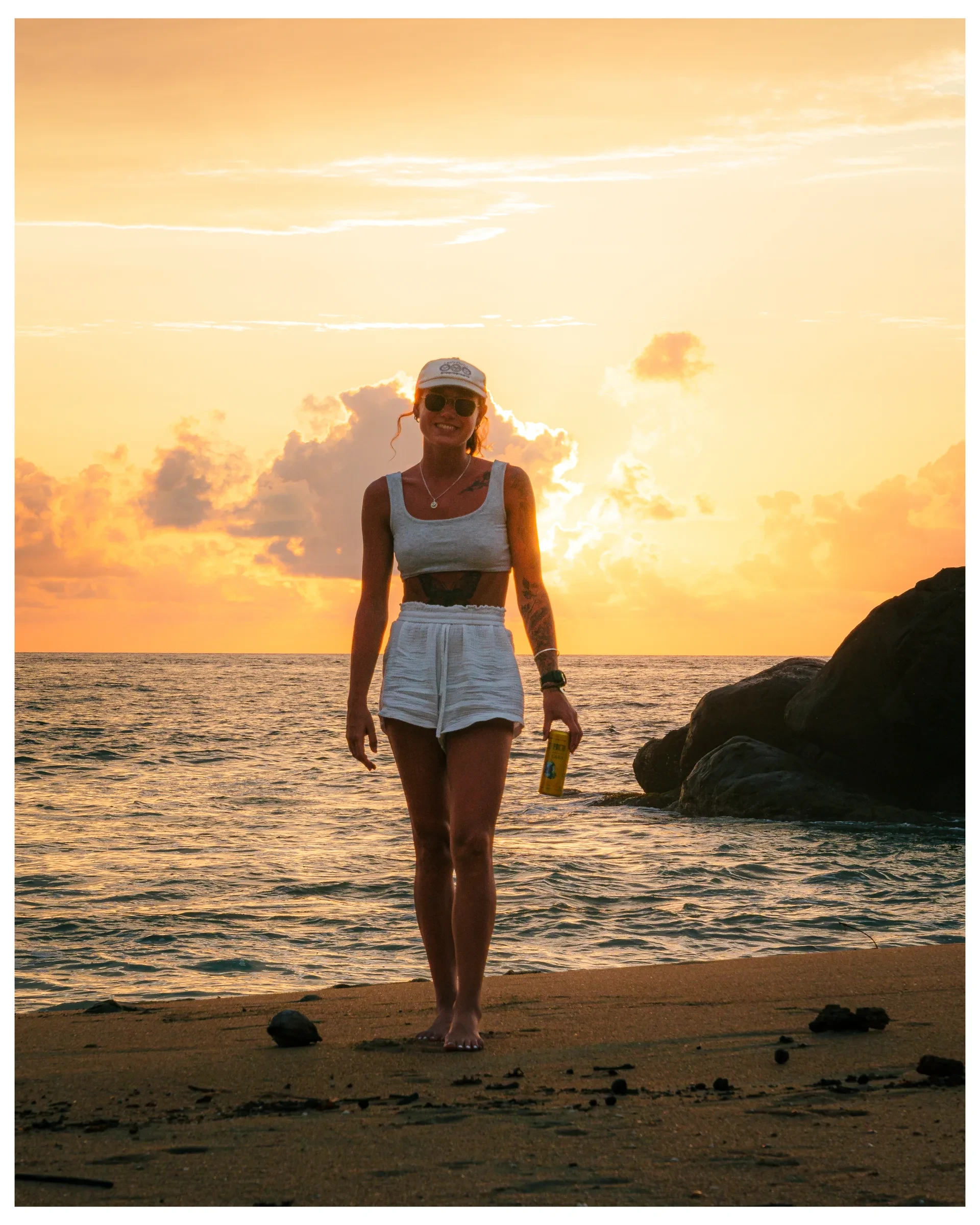 A person walking through shallow water at sunset
