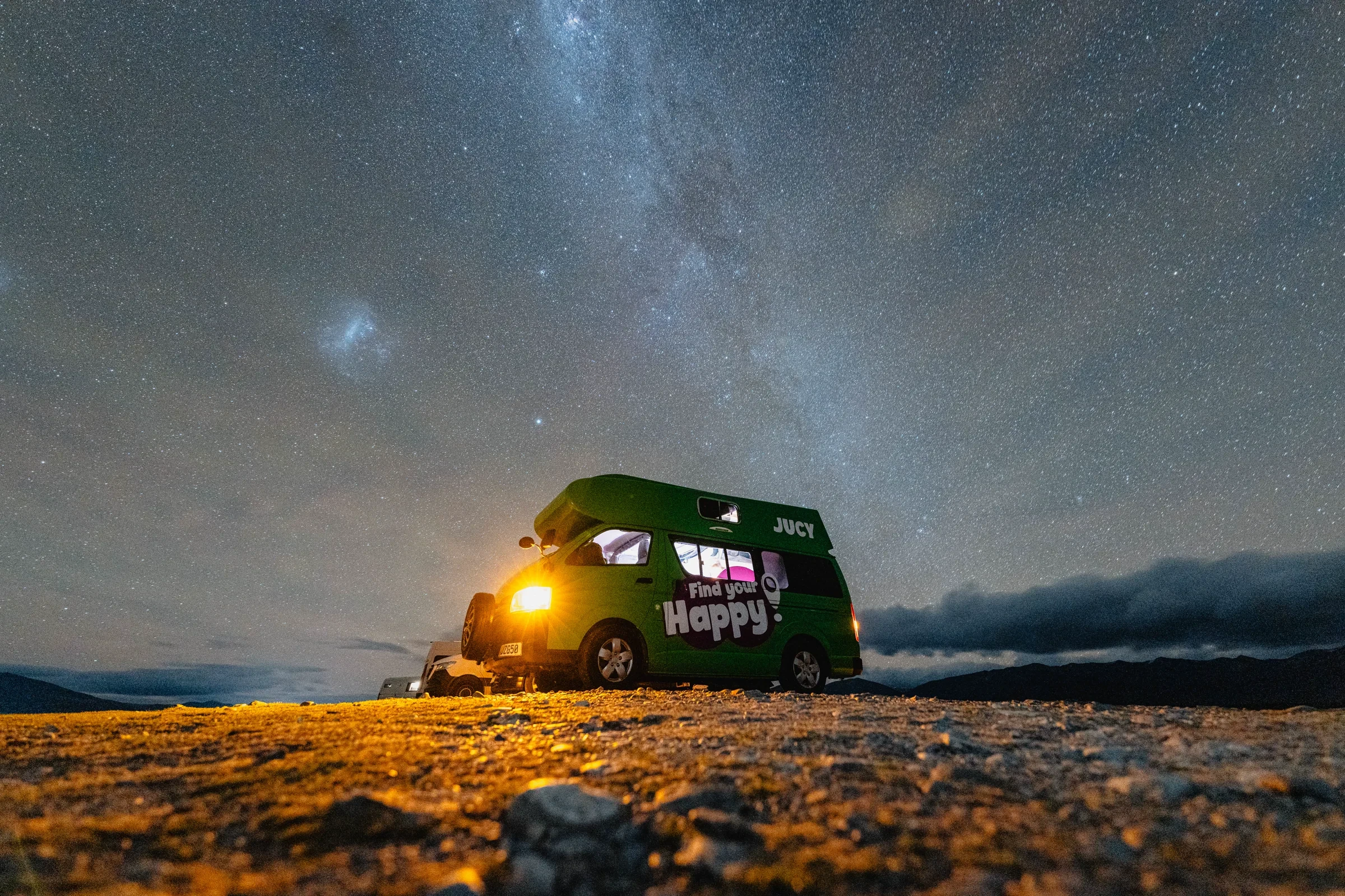 A camper van beneath a field of stars