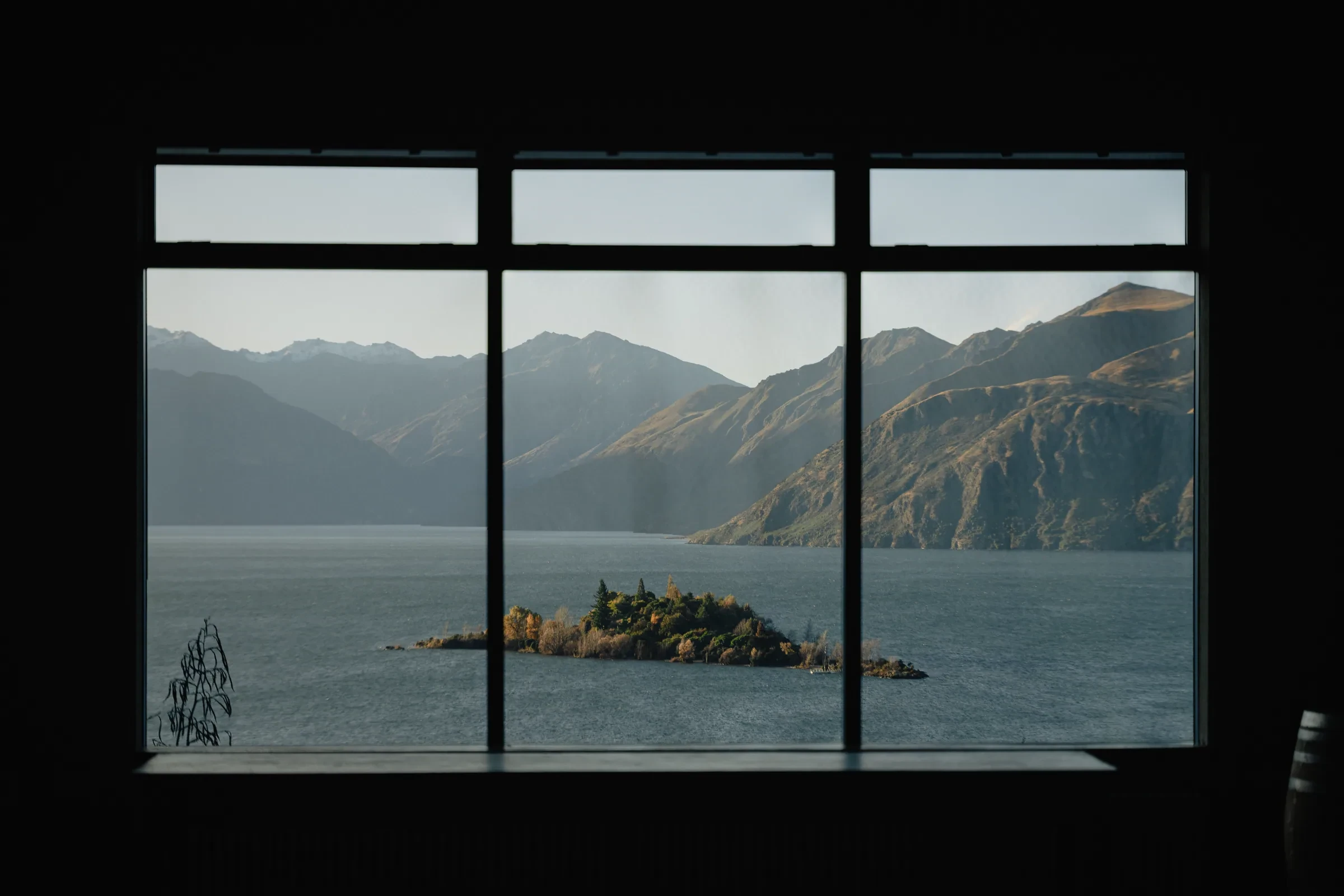A lake and mountain seen through a camper window