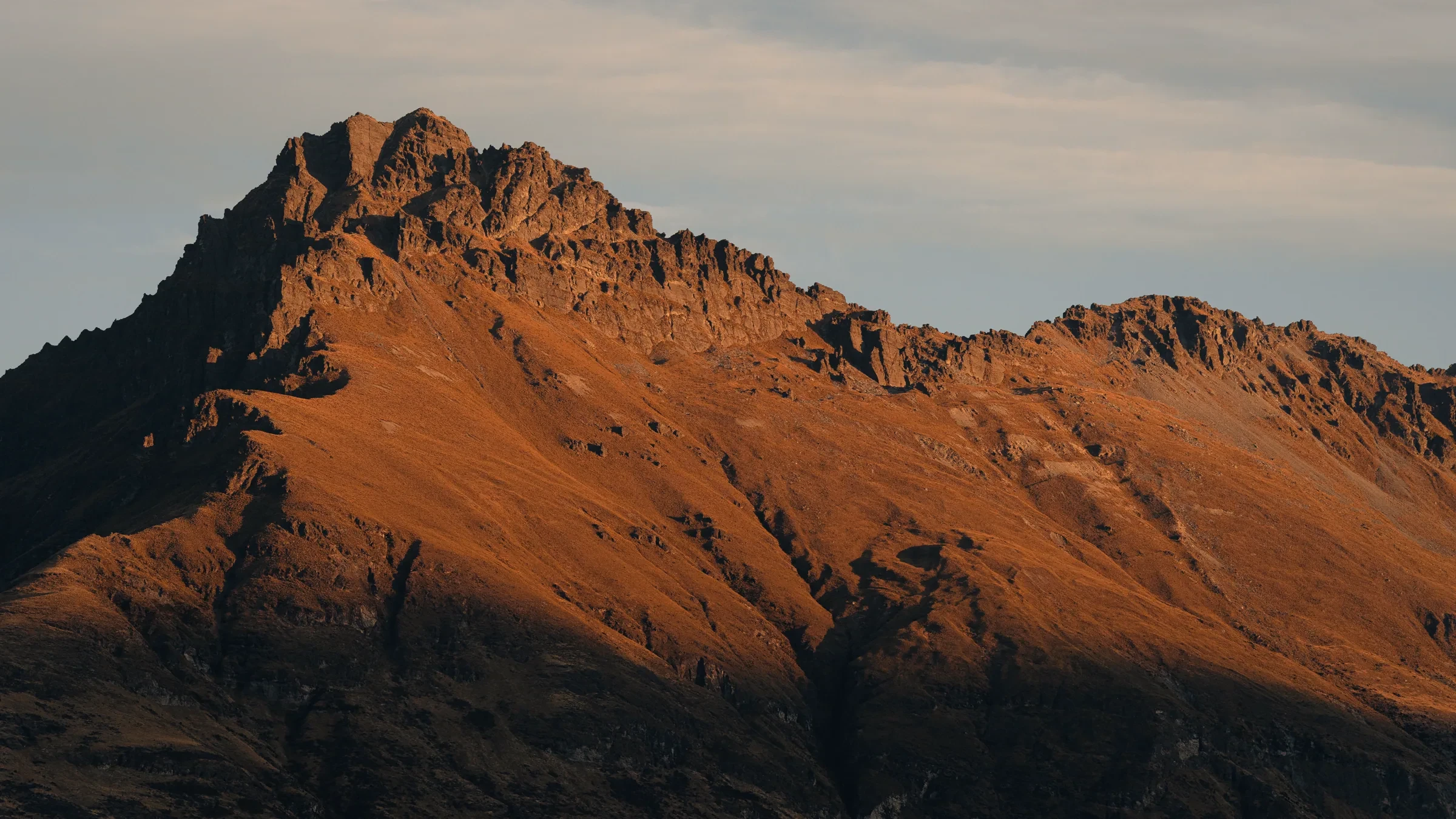 Warm light breaking across a distant mountain