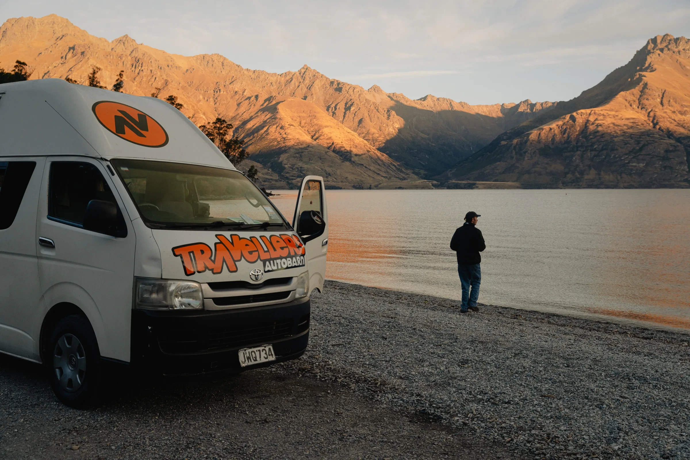A camper and traveller beside a mountain lake