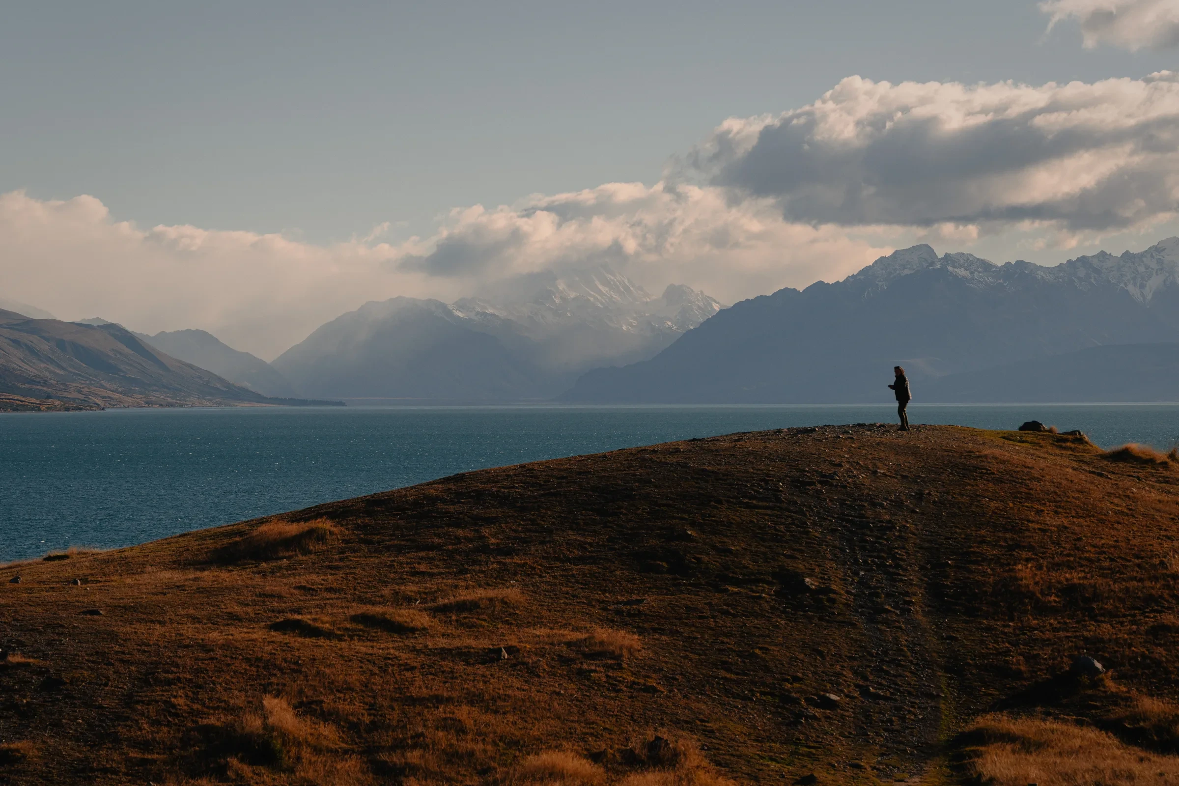 A lone figure above a mountain lake