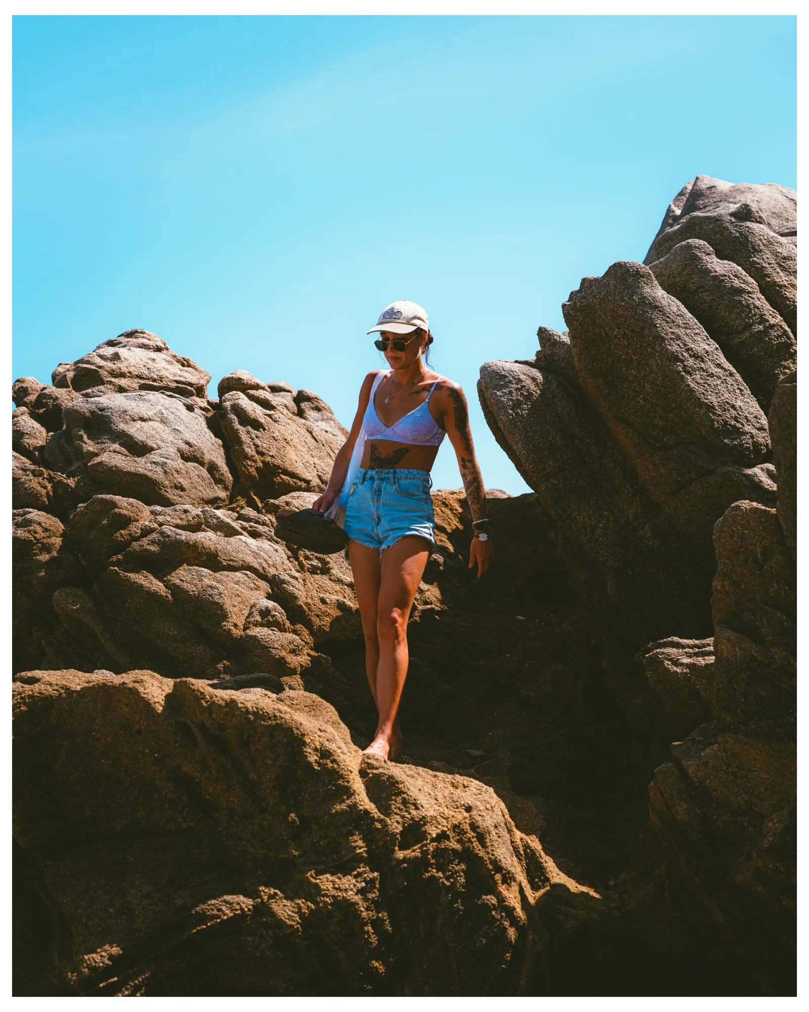 A traveller moving through sunlit coastal rocks