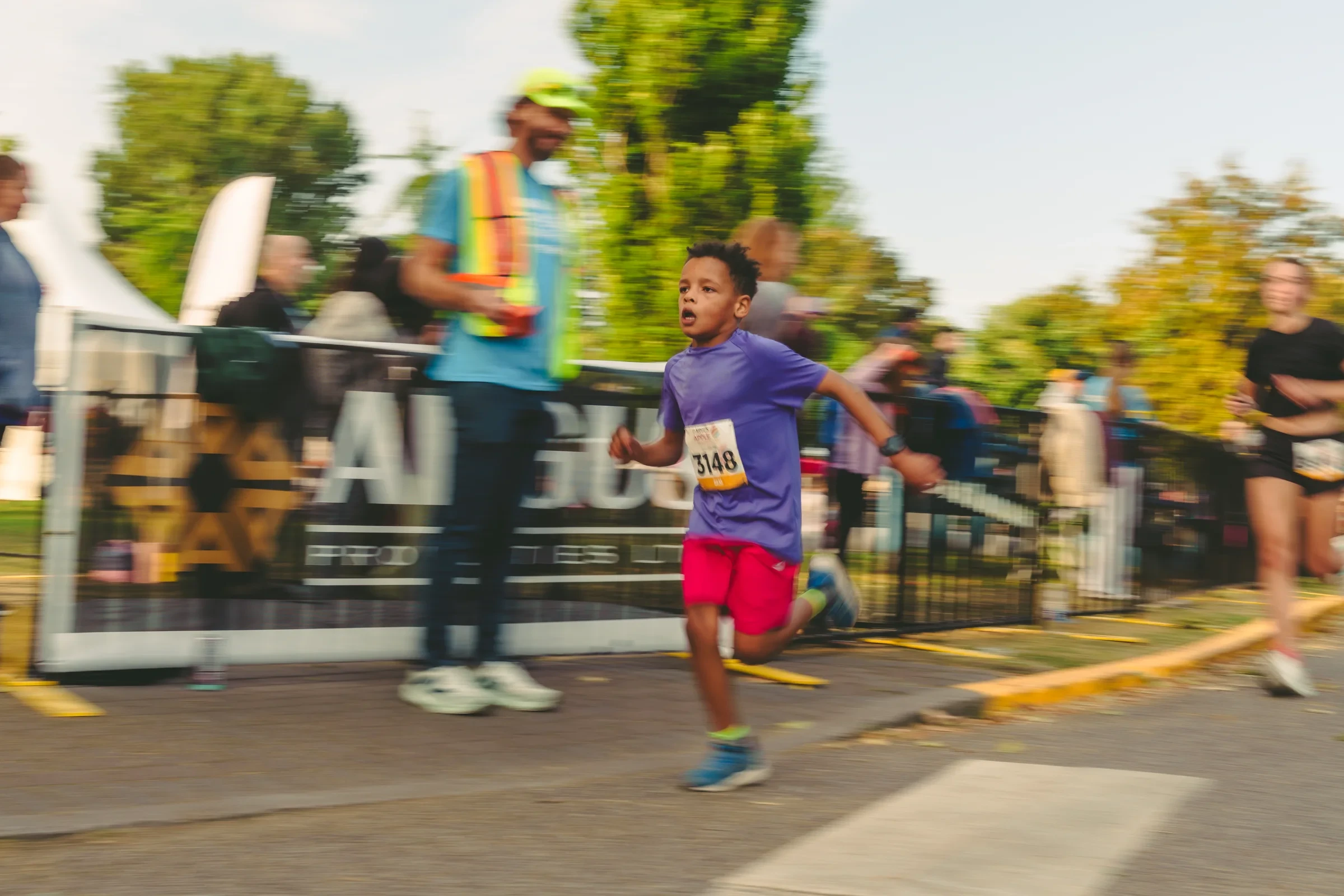 A young runner moving past the finish area at the Kelowna Apple Marathon