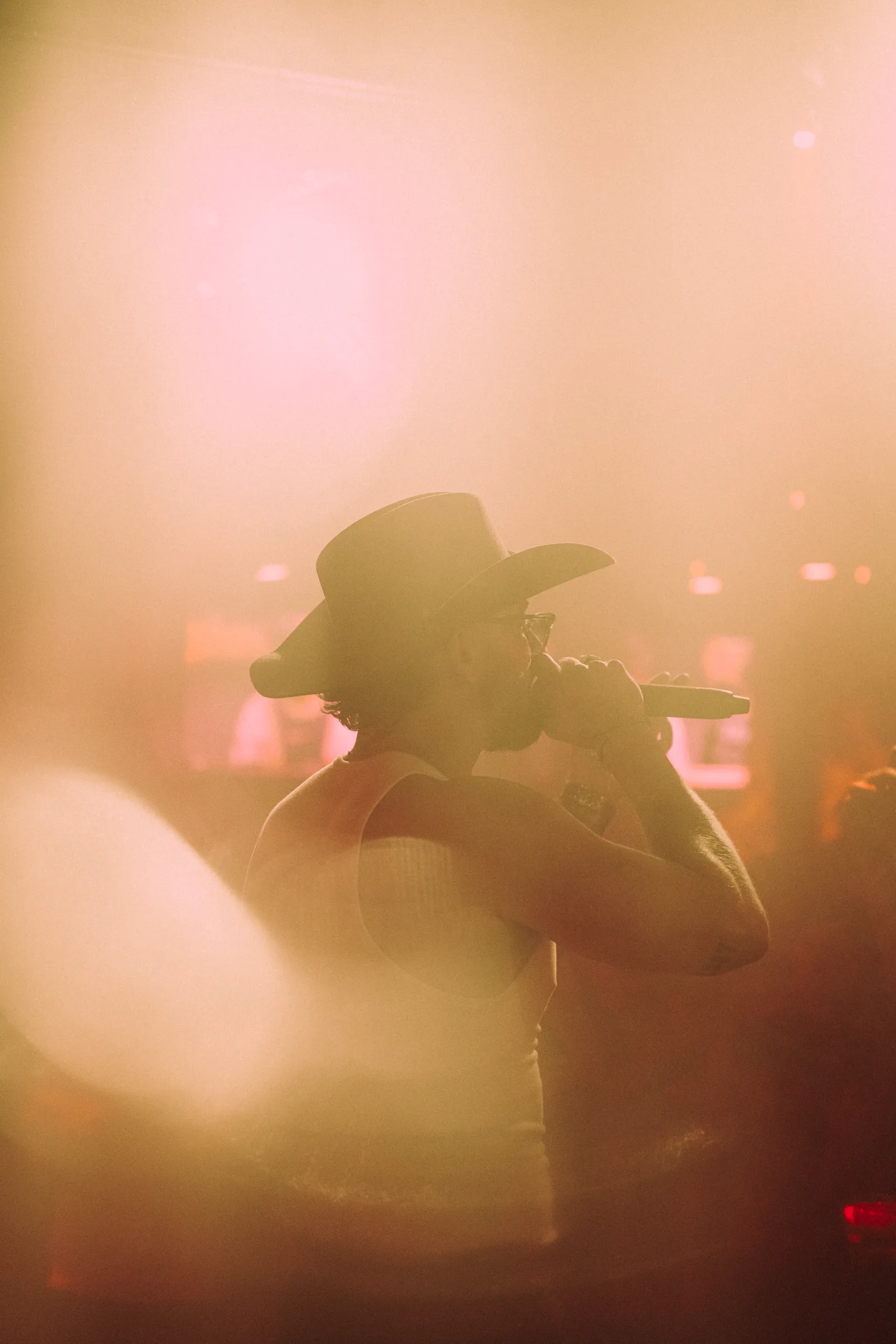 A performer silhouetted by warm stage light