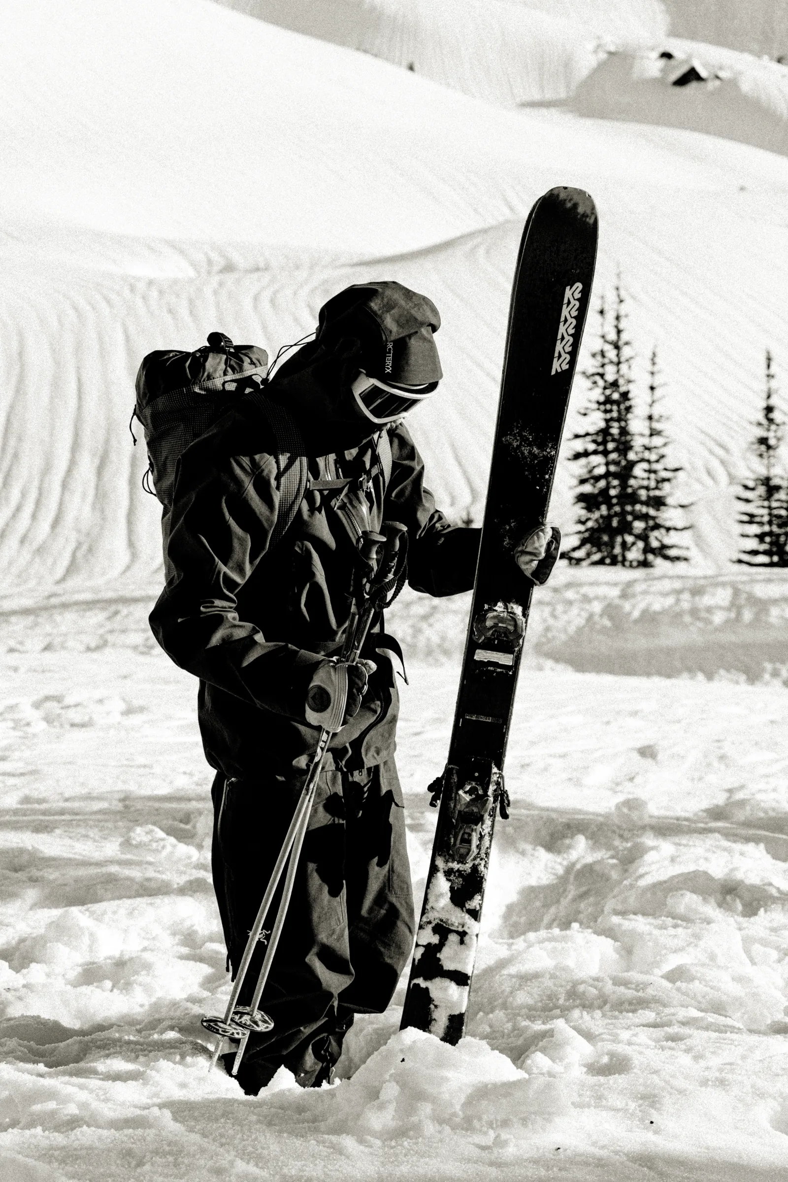 A skier carrying equipment on a snowy ridge
