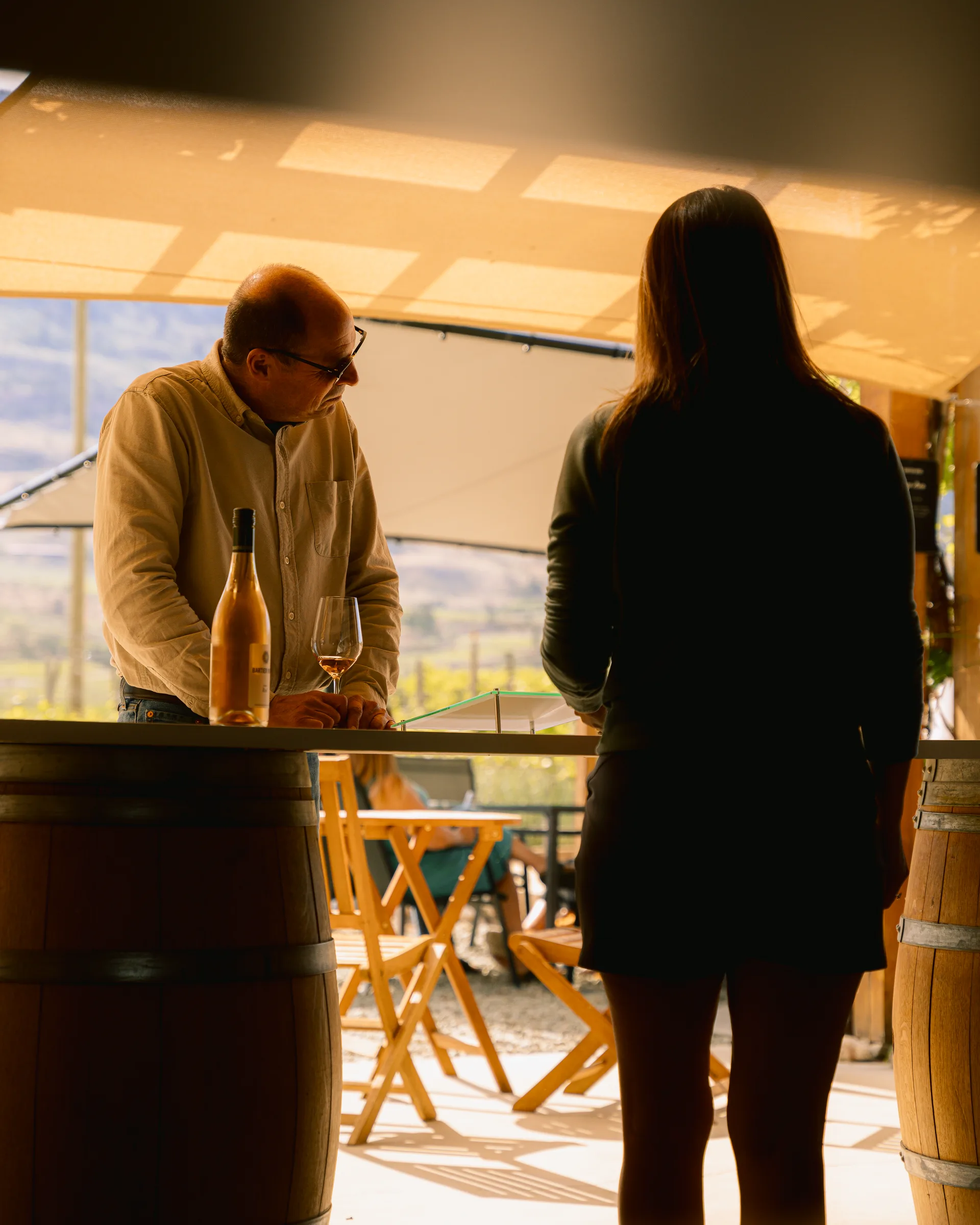 Two people talking over wine at the vineyard
