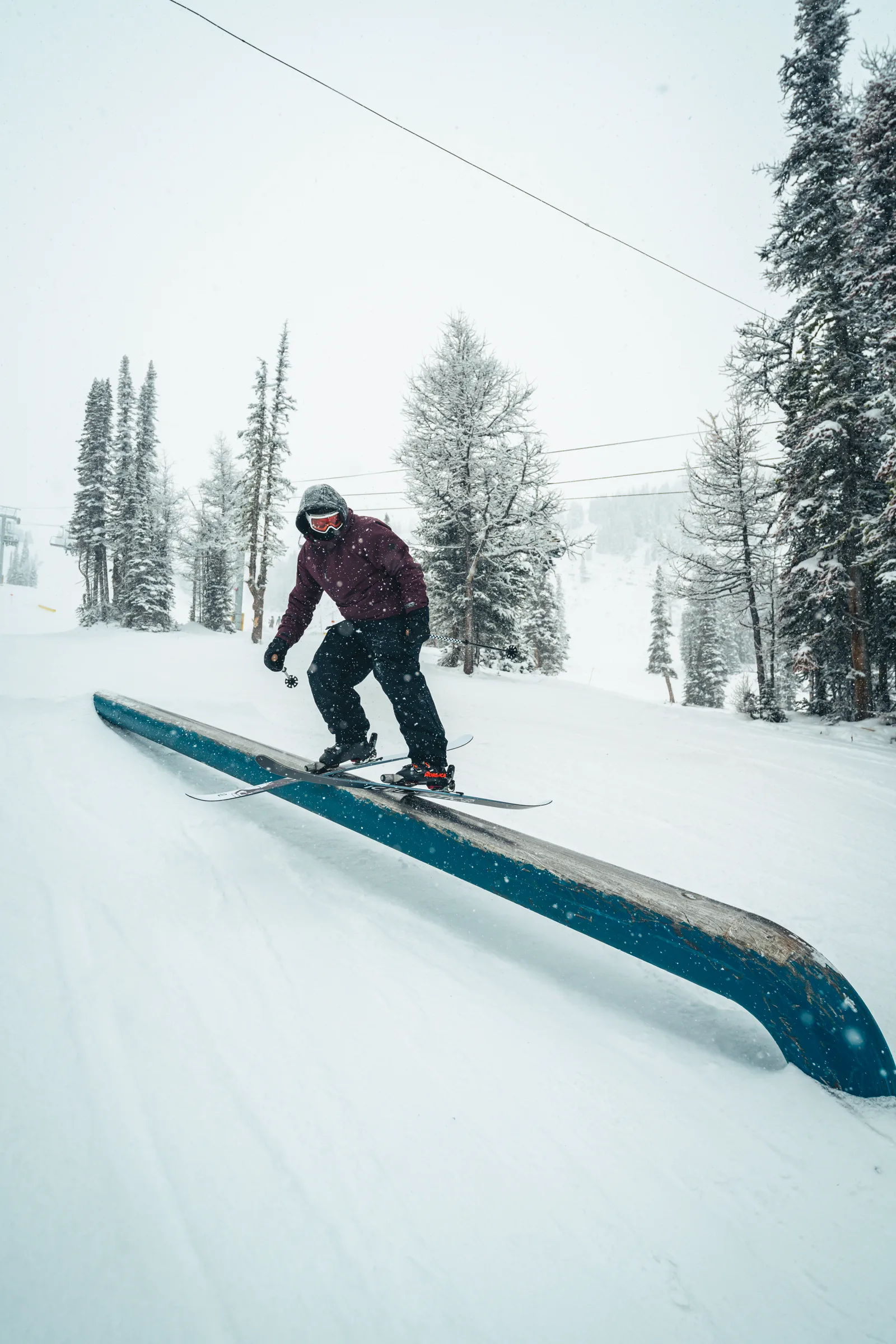 A skier balanced over a rail