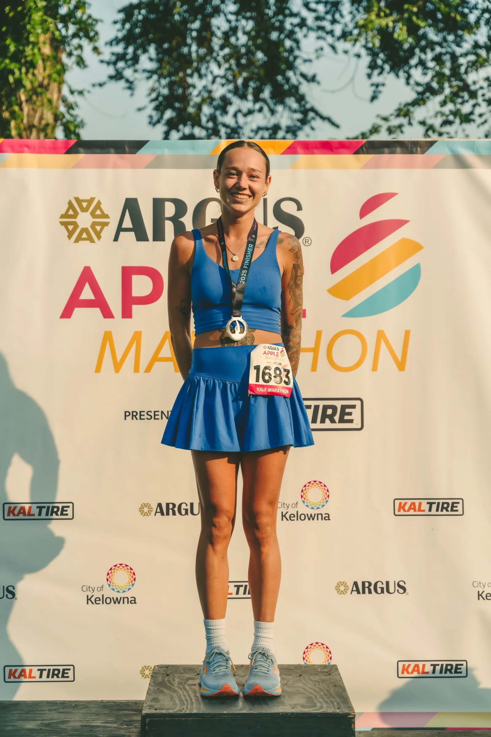 A runner standing on the Kelowna Apple Marathon podium