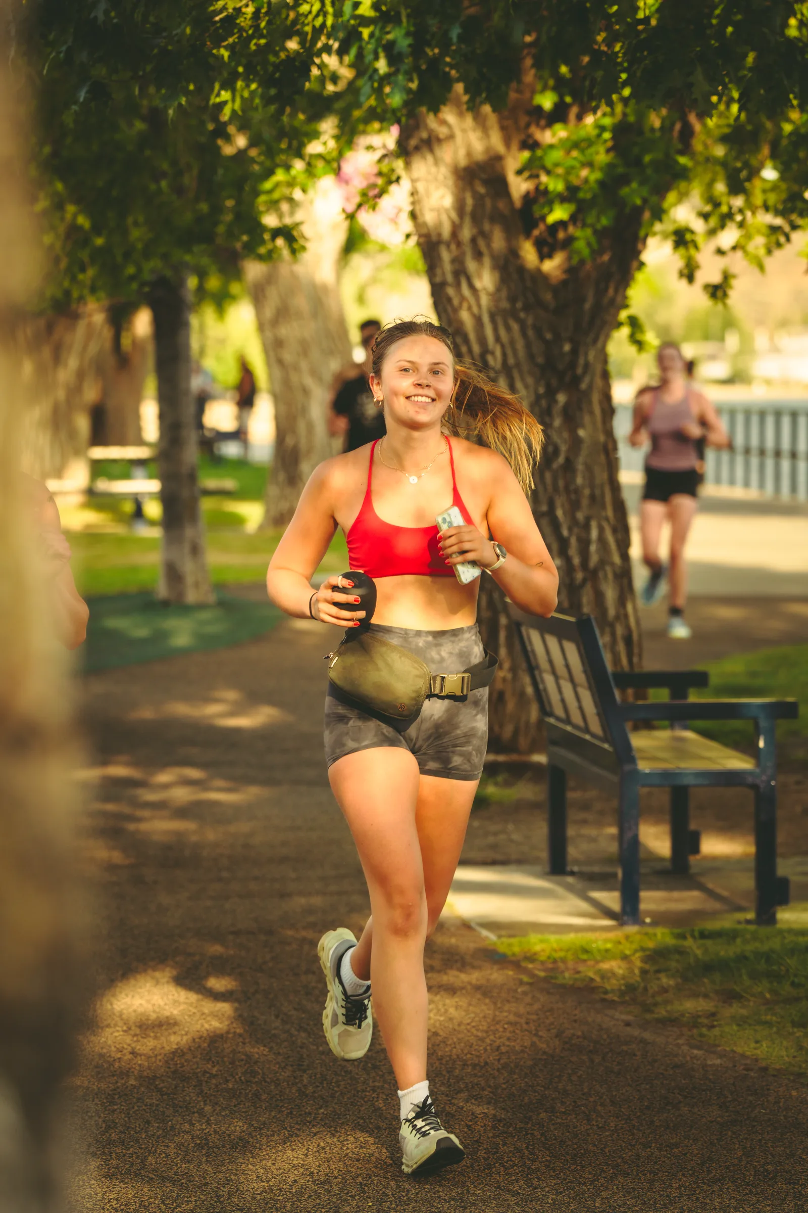 A runner passing a bench beside the lake