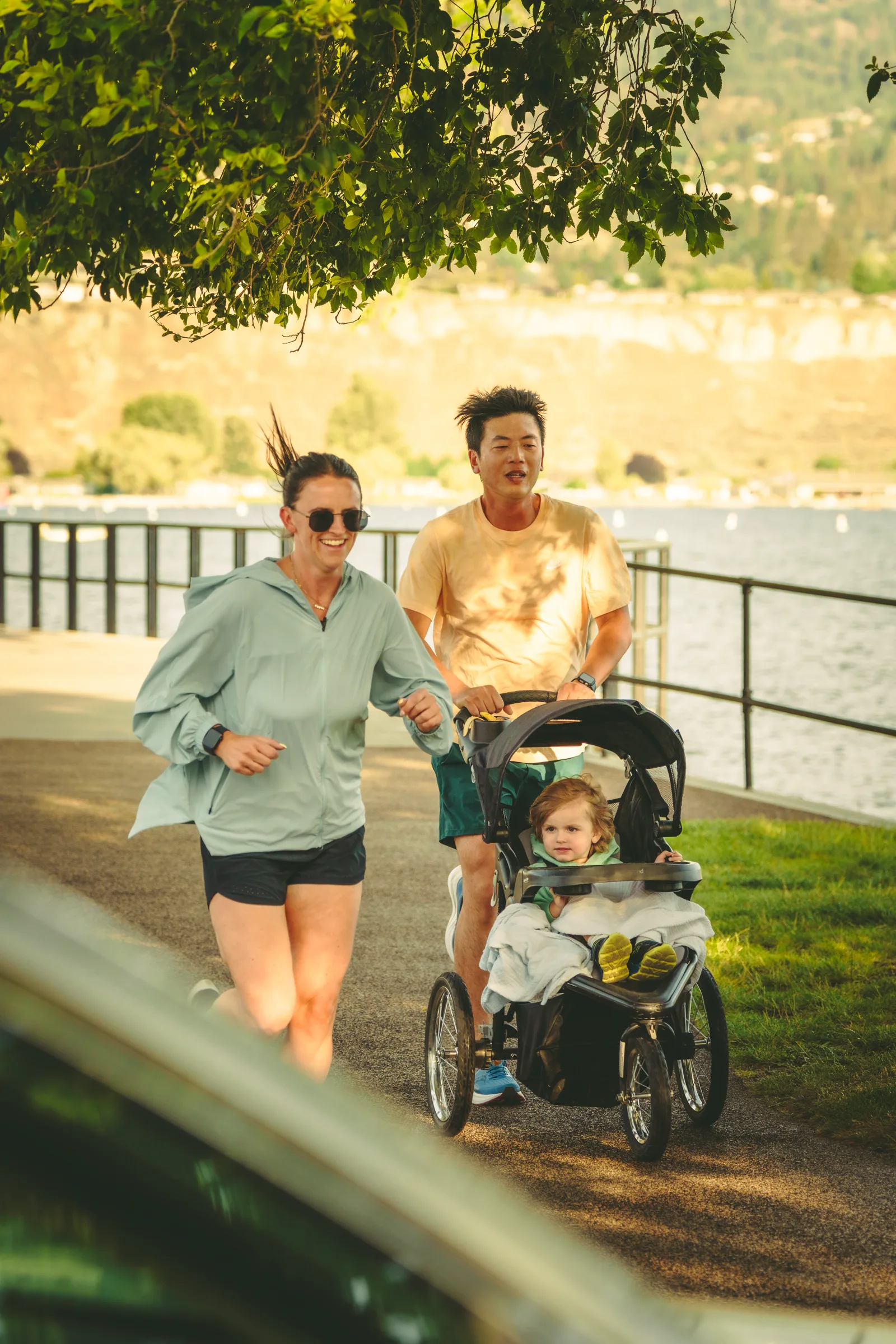 Runners and a stroller moving along the waterfront