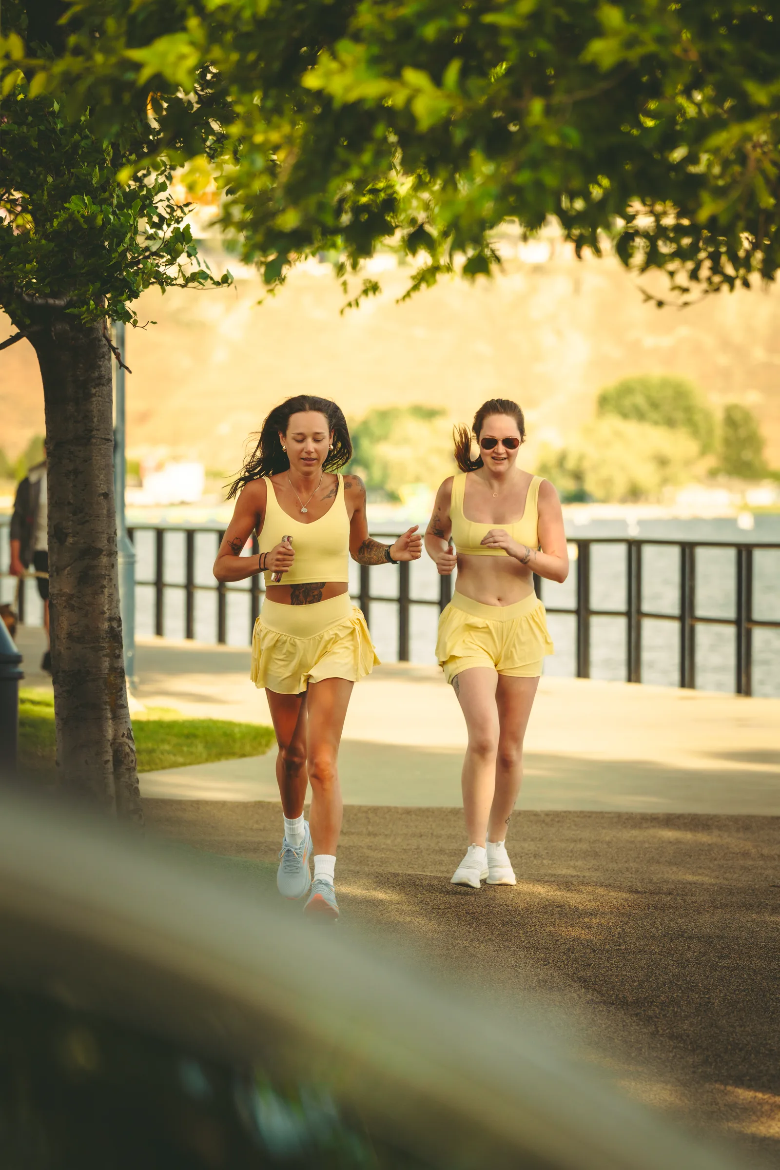 Two runners together beside the lake