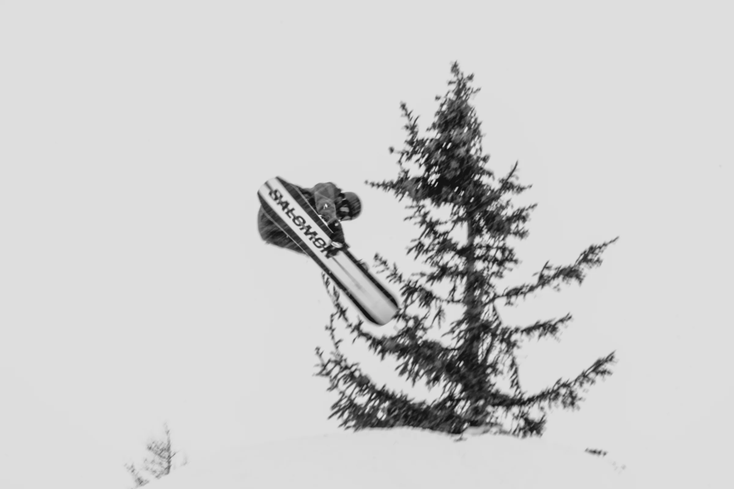 A skier suspended above the slope in black and white