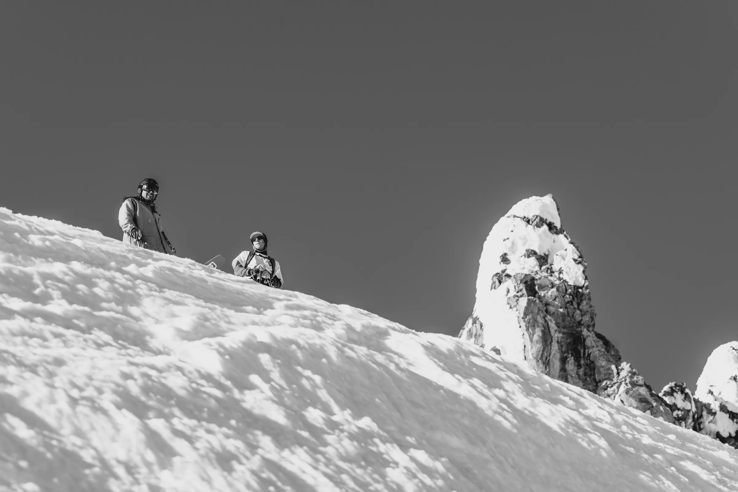 A group gathered below an alpine peak