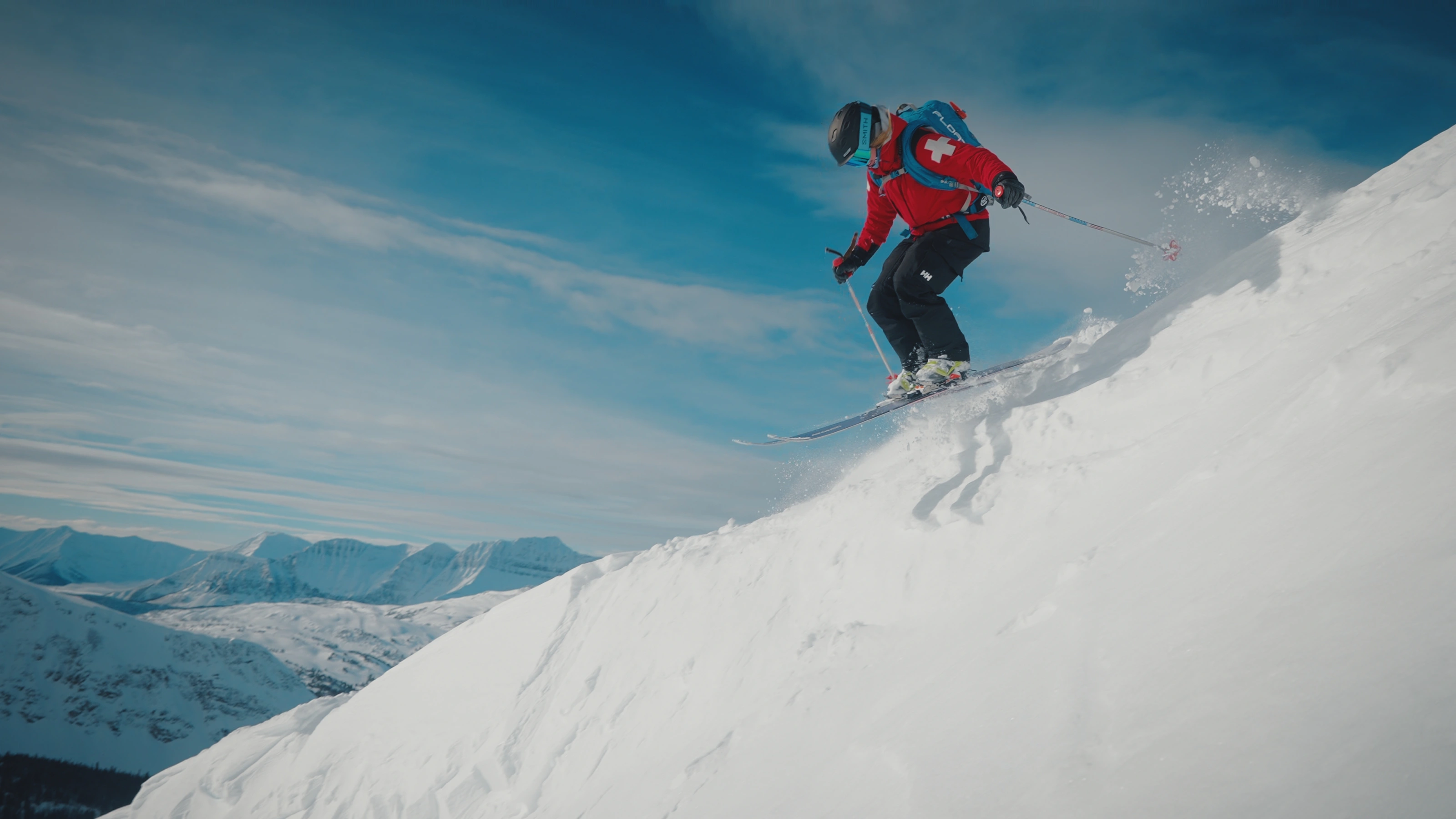 A ski patroller descending an alpine slope