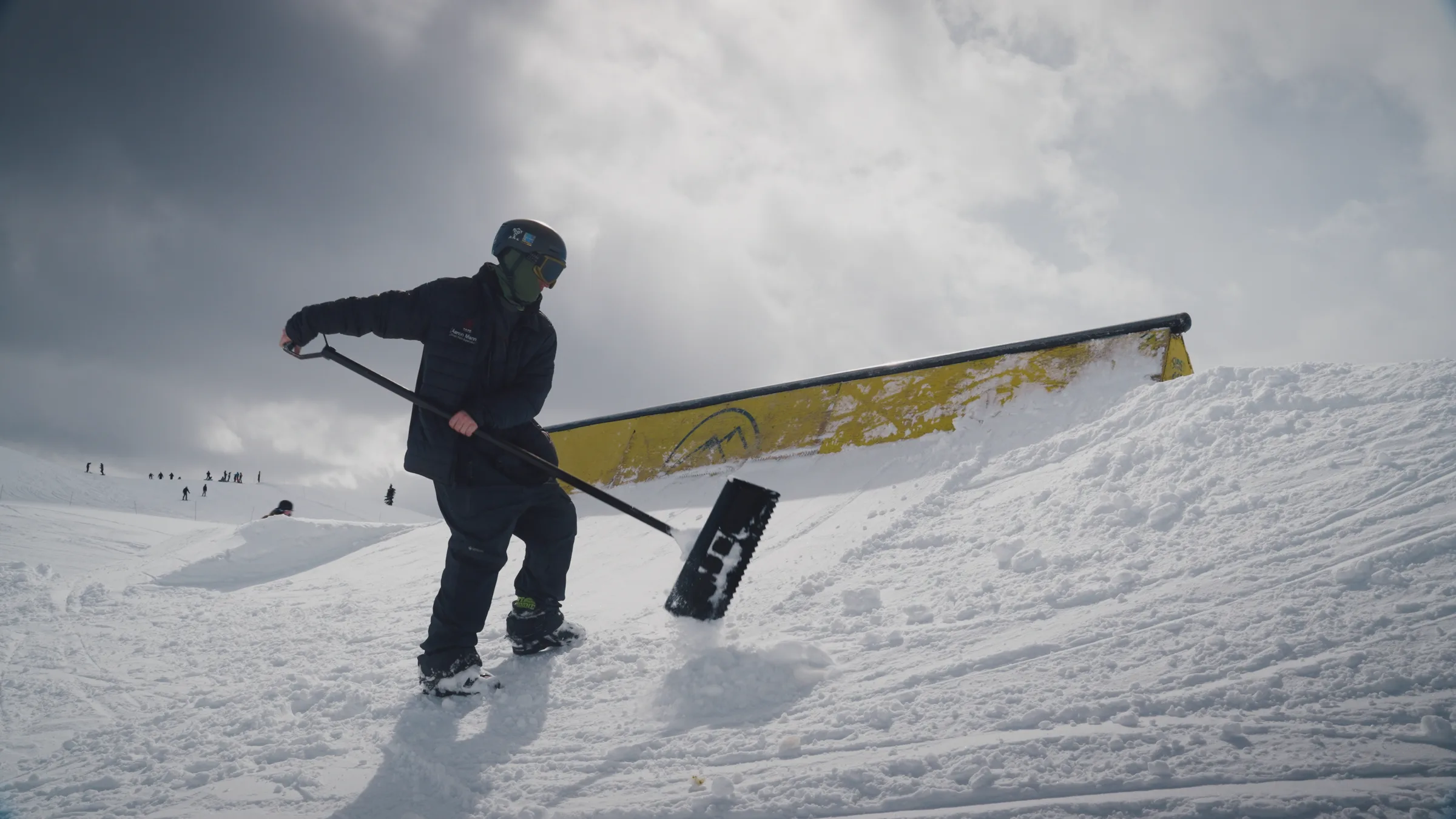 A terrain-park team member maintaining a rail feature