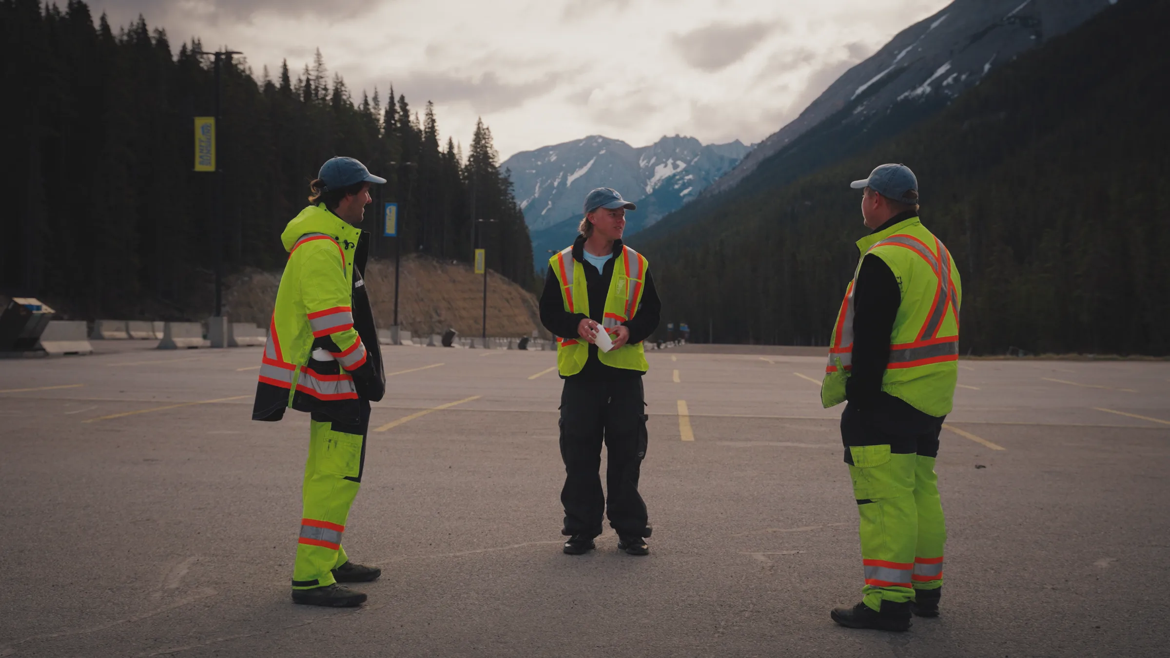 Three operations team members meeting in a mountain parking area