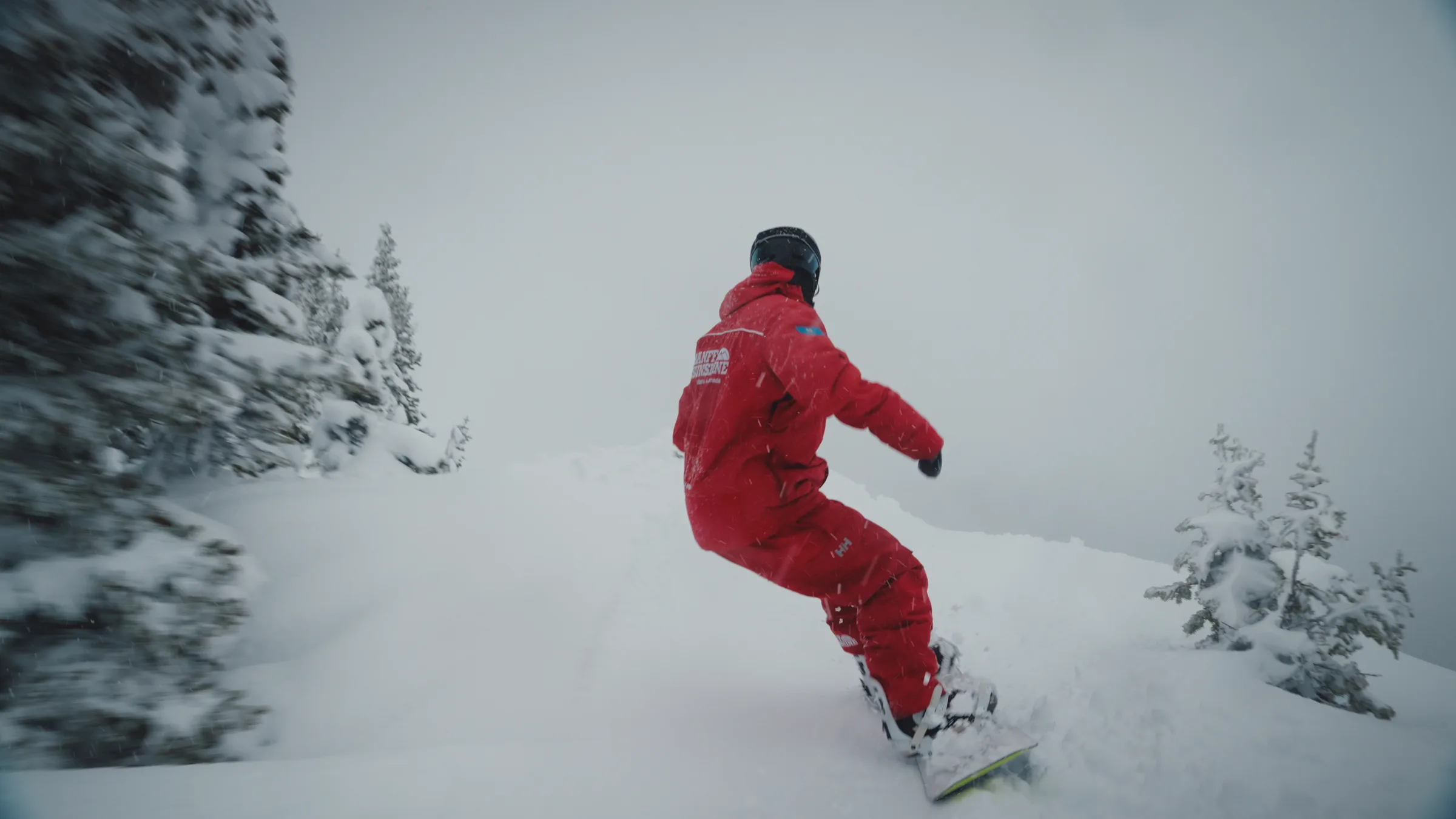 A snowboard patroller riding through fresh snow