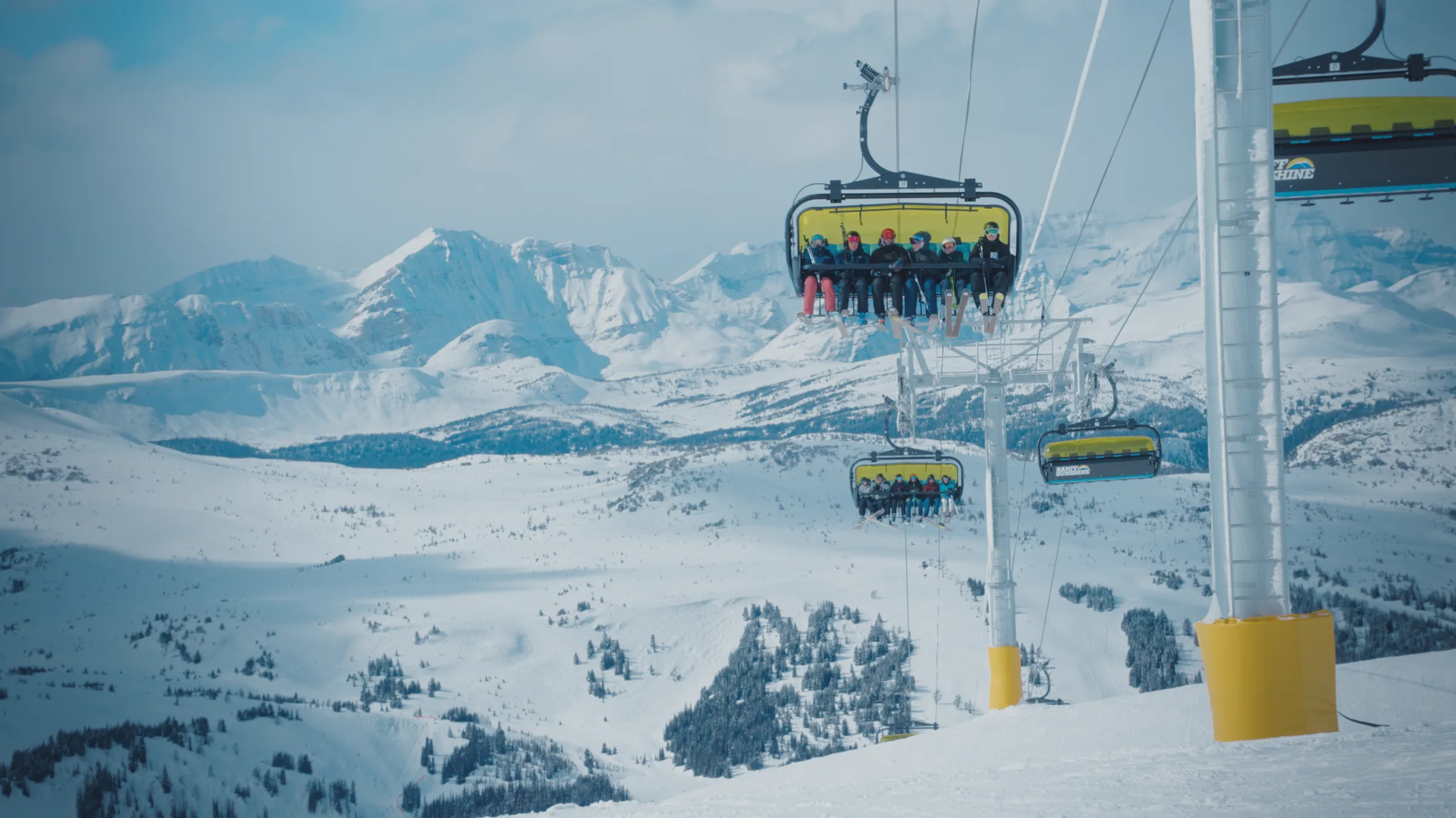 Skiers riding a chairlift above the alpine landscape