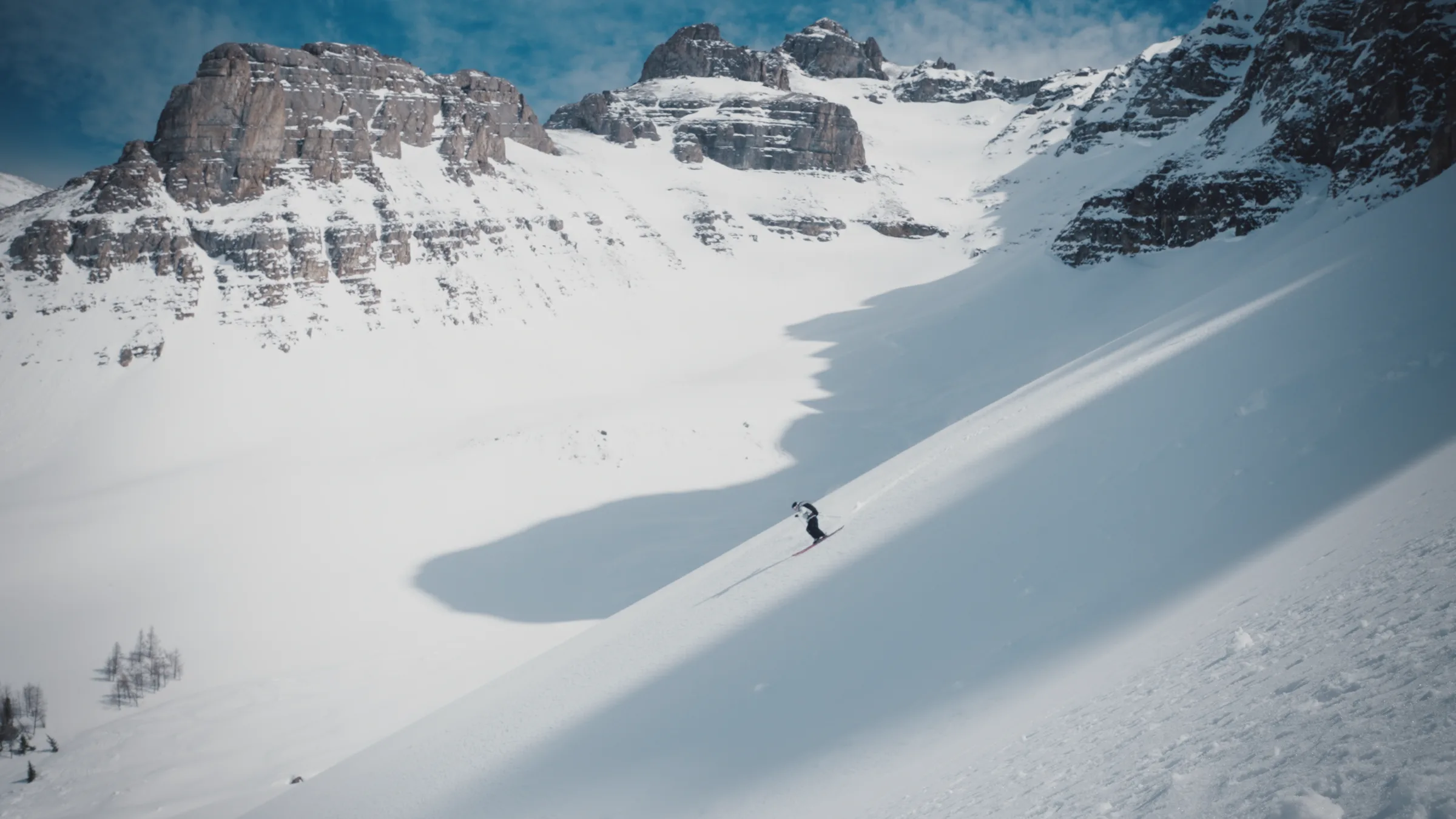 A skier crossing a sunlit alpine slope at Banff Sunshine Village